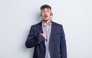 Şok olmuş ve ağzı açık, kendini işaret eden genç ve yakışıklı bir adam. tele pazarlamacı kavramı