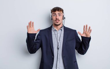 Genç yakışıklı adam ellerini havaya kaldırarak çığlık atıyor. tele pazarlamacı kavramı