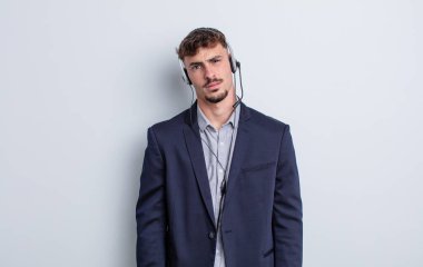 Genç yakışıklı adam şaşkın ve şaşkın hissediyor. tele pazarlamacı kavramı