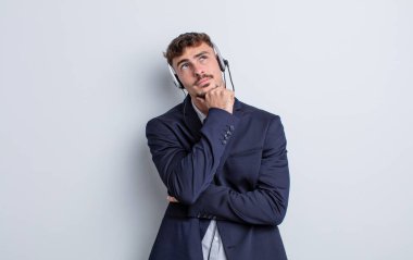 Genç yakışıklı düşünen, kuşkulu ve kafası karışık bir adam. tele pazarlamacı kavramı