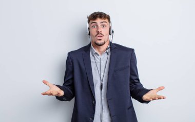 Genç ve yakışıklı bir adam şok olmuş ve şaşırmış hissediyor. tele pazarlamacı kavramı