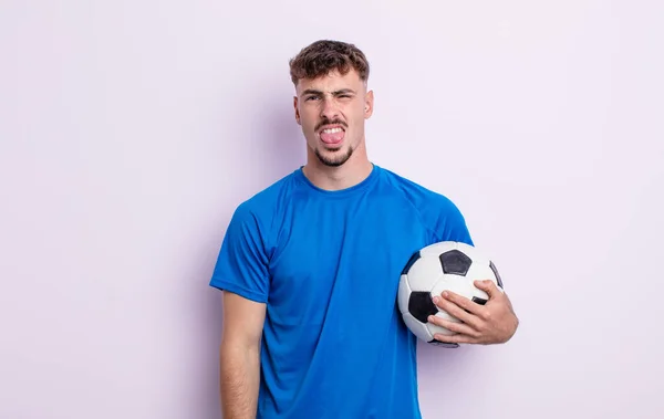 若いハンサムな男はうんざりしていらいらして舌を出す サッカーのコンセプト — ストック写真