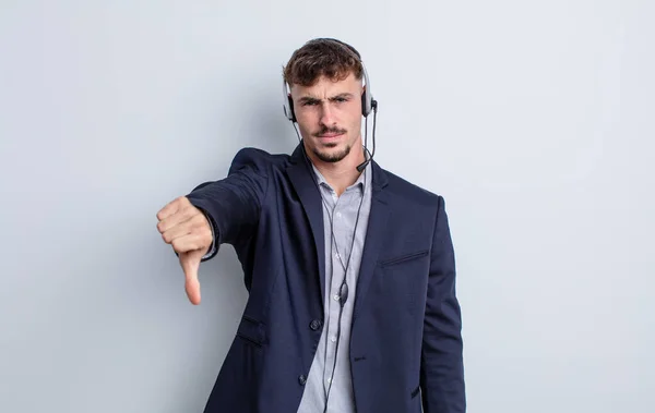 Jovem Bonito Homem Sentindo Cruz Mostrando Polegares Para Baixo Conceito — Fotografia de Stock