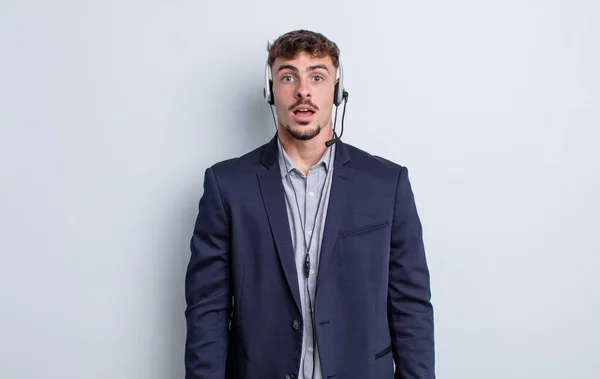 Joven Hombre Guapo Buscando Muy Sorprendido Sorprendido Concepto Telemarketer — Foto de Stock