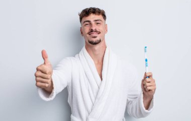 Genç ve yakışıklı bir adam gururlu, olumlu gülümsüyor. diş fırçası kavramı