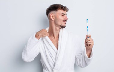 Genç ve yakışıklı adam stresli, endişeli, yorgun ve hayal kırıklığına uğramış hissediyor. diş fırçası kavramı