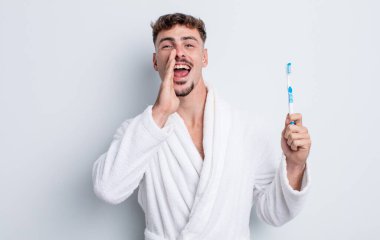 Genç yakışıklı adam mutlu hissediyor, elleri ağzının kenarında bağırıyor. diş fırçası kavramı