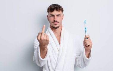 Genç ve yakışıklı bir adam sinirli, sinirli, asi ve agresif hissediyor. diş fırçası kavramı