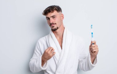 Genç yakışıklı adam kibirli, başarılı, pozitif ve gururlu görünüyor. diş fırçası kavramı