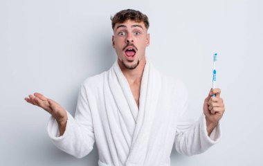 Genç yakışıklı adam, inanılmaz bir sürprizle şaşkına dönmüş ve hayrete düşmüştü. diş fırçası kavramı