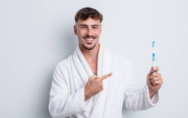 Genç yakışıklı adam heyecanlı ve şaşırmış görünüyor. diş fırçası kavramı