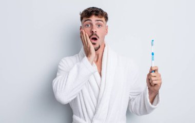 Genç ve yakışıklı bir adam şok olmuş ve korkmuş hissediyor. diş fırçası kavramı