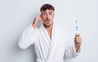 Genç yakışıklı adam şaşırmış görünüyor, yeni bir düşünce, fikir ya da konsept fark ediyor. diş fırçası kavramı