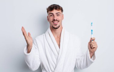 Genç yakışıklı adam kendini mutlu hissediyor, bir çözüm ya da fikir bulduğuna şaşırıyor. diş fırçası kavramı