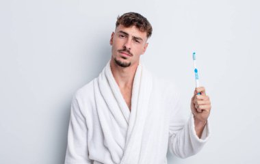 Genç yakışıklı adam şaşkın ve şaşkın hissediyor. diş fırçası kavramı