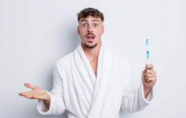 Genç ve yakışıklı bir adam şok olmuş ve şaşırmış hissediyor. diş fırçası kavramı