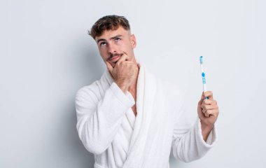 Genç yakışıklı düşünen, kuşkulu ve kafası karışık bir adam. diş fırçası kavramı
