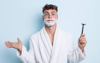 Genç yakışıklı adam şaşkın, şaşkın ve şüpheci hissediyor. traş konsepti