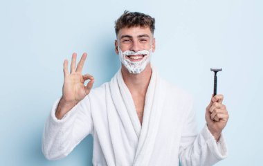 Genç yakışıklı adam kendini mutlu hissediyor, iyi bir jestle onaylıyor. traş konsepti