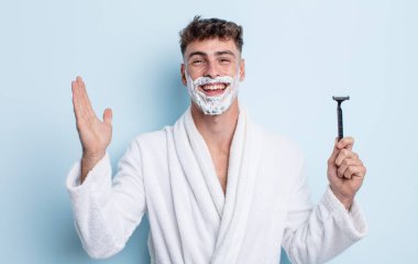 Genç yakışıklı adam kendini mutlu hissediyor ve inanılmaz bir şeye hayret ediyor. traş konsepti