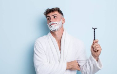Genç yakışıklı adam omuz silkiyor, kafası karışık ve kararsız. traş konsepti
