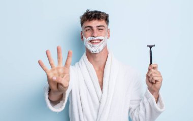 Genç yakışıklı adam gülümsüyor ve arkadaş canlısı görünüyor, dört numarayı gösteriyor. traş konsepti