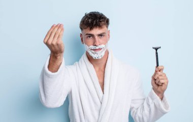 Genç yakışıklı adam kapiş ya da para hareketi yapıyor, sana ödemeni söylüyor. traş konsepti