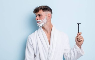 Profilde genç yakışıklı bir adam hayal kuruyor, hayal kuruyor ya da hayal kuruyor. traş konsepti