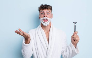 Genç yakışıklı adam, inanılmaz bir sürprizle şaşkına dönmüş ve hayrete düşmüştü. traş konsepti