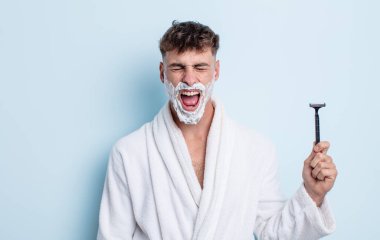 Genç yakışıklı adam agresif bir şekilde bağırıyor, çok kızgın görünüyor. traş konsepti