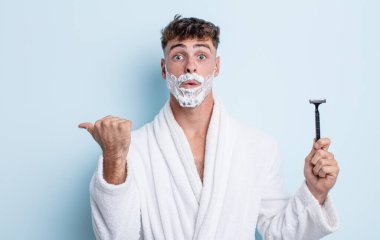 İnanamadığı için şaşırmış genç ve yakışıklı bir adam. traş konsepti