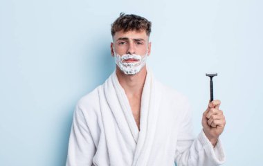 Genç ve yakışıklı bir adam üzgün ve mızmızlanıyor. Mutsuz bir bakışı var ve ağlıyor. traş konsepti