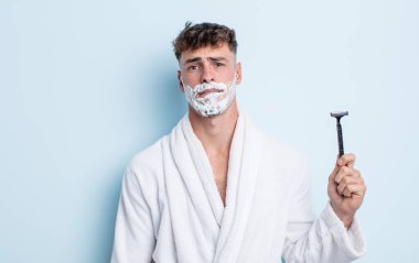 Kafası karışmış ve kafası karışmış genç yakışıklı bir adam. traş konsepti