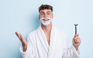 Genç yakışıklı adam kendini mutlu hissediyor, bir çözüm ya da fikir bulduğuna şaşırıyor. traş konsepti