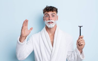 Genç yakışıklı adam ellerini havaya kaldırarak çığlık atıyor. traş konsepti