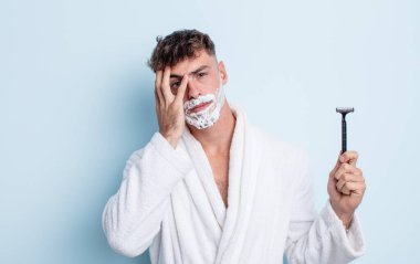 Genç yakışıklı bir adam bıkkın, hayal kırıklığına uğramış ve yorucu bir geceden sonra uykulu hissediyor. traş konsepti