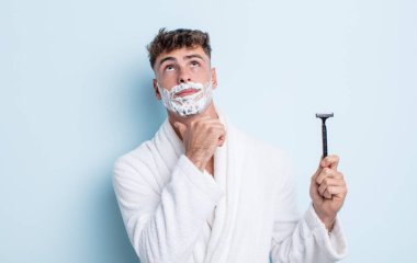 Genç yakışıklı düşünen, kuşkulu ve kafası karışık bir adam. traş konsepti