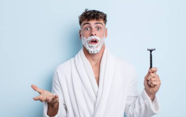 Genç ve yakışıklı bir adam şok olmuş ve şaşırmış hissediyor. traş konsepti