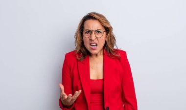 Oldukça orta yaşlı bir kadın sinirli, sinirli ve hayal kırıklığına uğramış görünüyor. İş kadını kavramı