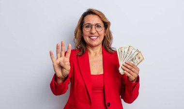 Güzel orta yaşlı kadın gülümsüyor ve arkadaş canlısı görünüyor, dört numarayı gösteriyor. Dolar banknotları konsepti