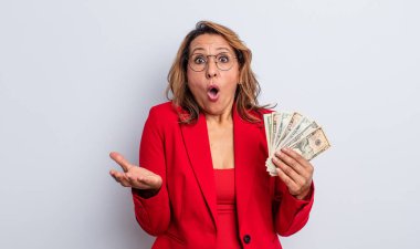 Oldukça orta yaşlı bir kadın inanılmaz bir sürprizle şaşkına dönmüş ve hayrete düşmüştü. Dolar banknotları konsepti