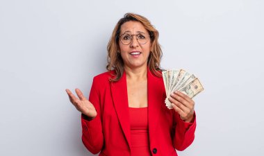 Oldukça orta yaşlı bir kadın mutlu hissediyor, bir çözüm ya da fikir bulduğuna şaşırıyor. Dolar banknotları konsepti