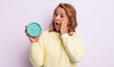 Oldukça orta yaşlı bir kadın mutlu, heyecanlı ve şaşırmış hissediyor. Alarm saati kavramı