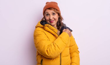 Orta yaşlı güzel bir kadın kendini mutlu hissediyor ve bir meydan okumayla yüzleşiyor ya da kutluyor. kış konsepti