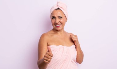 Güzel, orta yaşlı bir kadın gururlu, olumlu gülümsüyor. güzellik ve duş konsepti