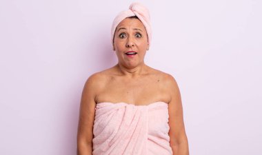 Güzel, orta yaşlı bir kadın çok şaşırmış ya da şaşkın görünüyor. güzellik ve duş konsepti