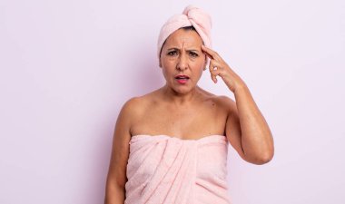 Oldukça orta yaşlı bir kadın kafası karışık ve şaşkın hissediyor, senin deli olduğunu gösteriyor. güzellik ve duş konsepti