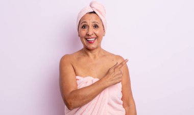 Oldukça orta yaşlı bir kadın heyecanlı ve şaşırmış görünüyor. güzellik ve duş konsepti