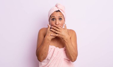 Güzel, orta yaşlı bir kadın elleri ile ağzını kapatıyor. güzellik ve duş konsepti