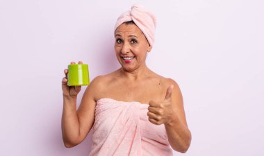 Güzel, orta yaşlı bir kadın gururlu, olumlu gülümsüyor. duş ve saç ürünü konsepti